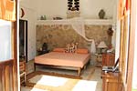 Orange bedroom with its King size bed and natural stone headboard